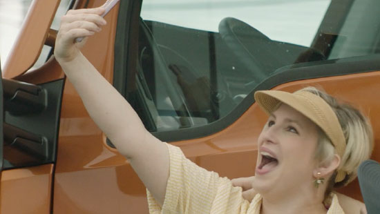 Tourist taking a selfie next to their vehicle