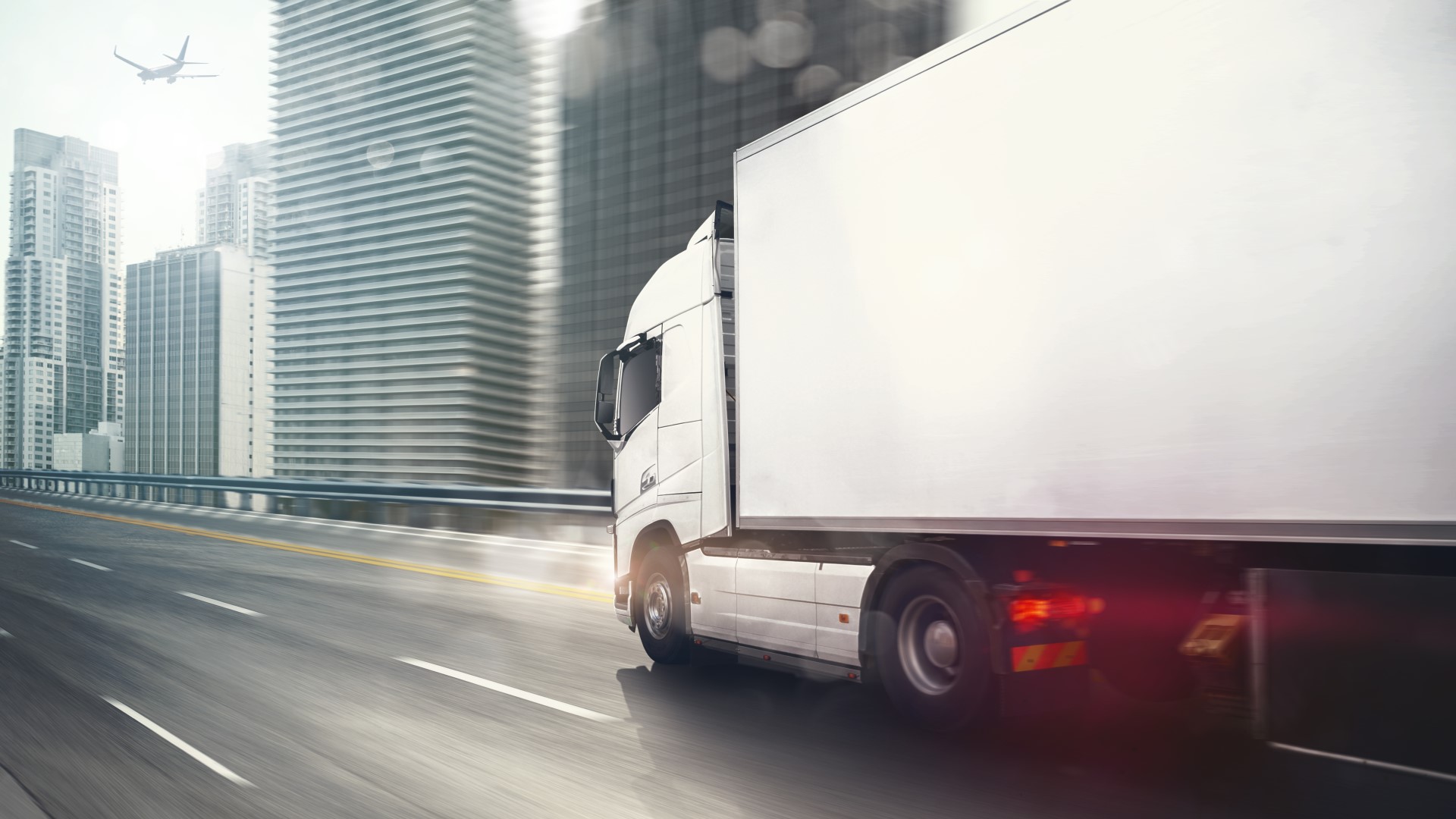 White truck driving on highway within a city