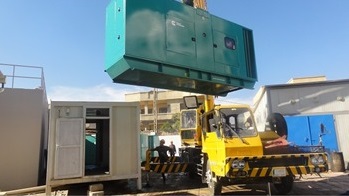 The generator is lifted to the site during installation.