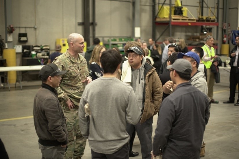 Colonel Adrian Marsh of the Department of Defense engages with Cummins employees who have worked on the AMMPS units.