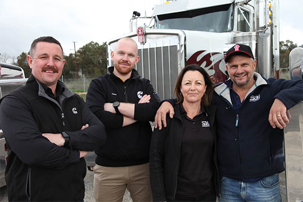 Employees standing in front of truck