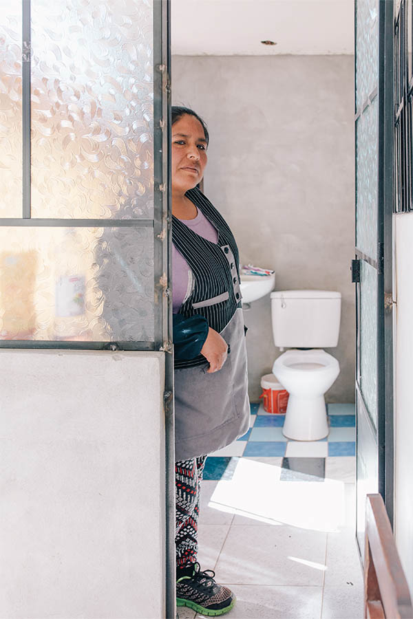 Woman standing next to new bathroom