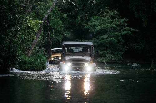 The Clean Cruisers wade through a stream in Central America