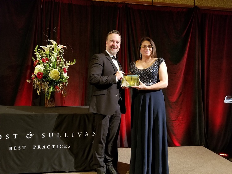 Cummins' Frank Friesacher, Executive Director of Product Commercialization, and Paula P. Watson, Director – Customer Success and Digital Solutions Integration, accept the Frost & Sullivan award. 