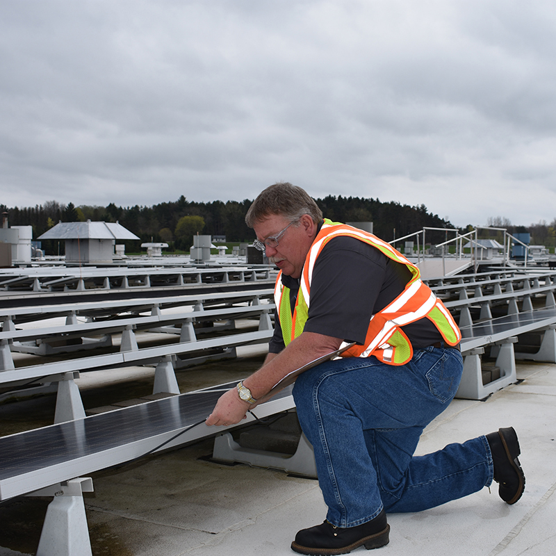 Jamestown Engine Plant electrician Fred Gable inspects the solar panel connections at 