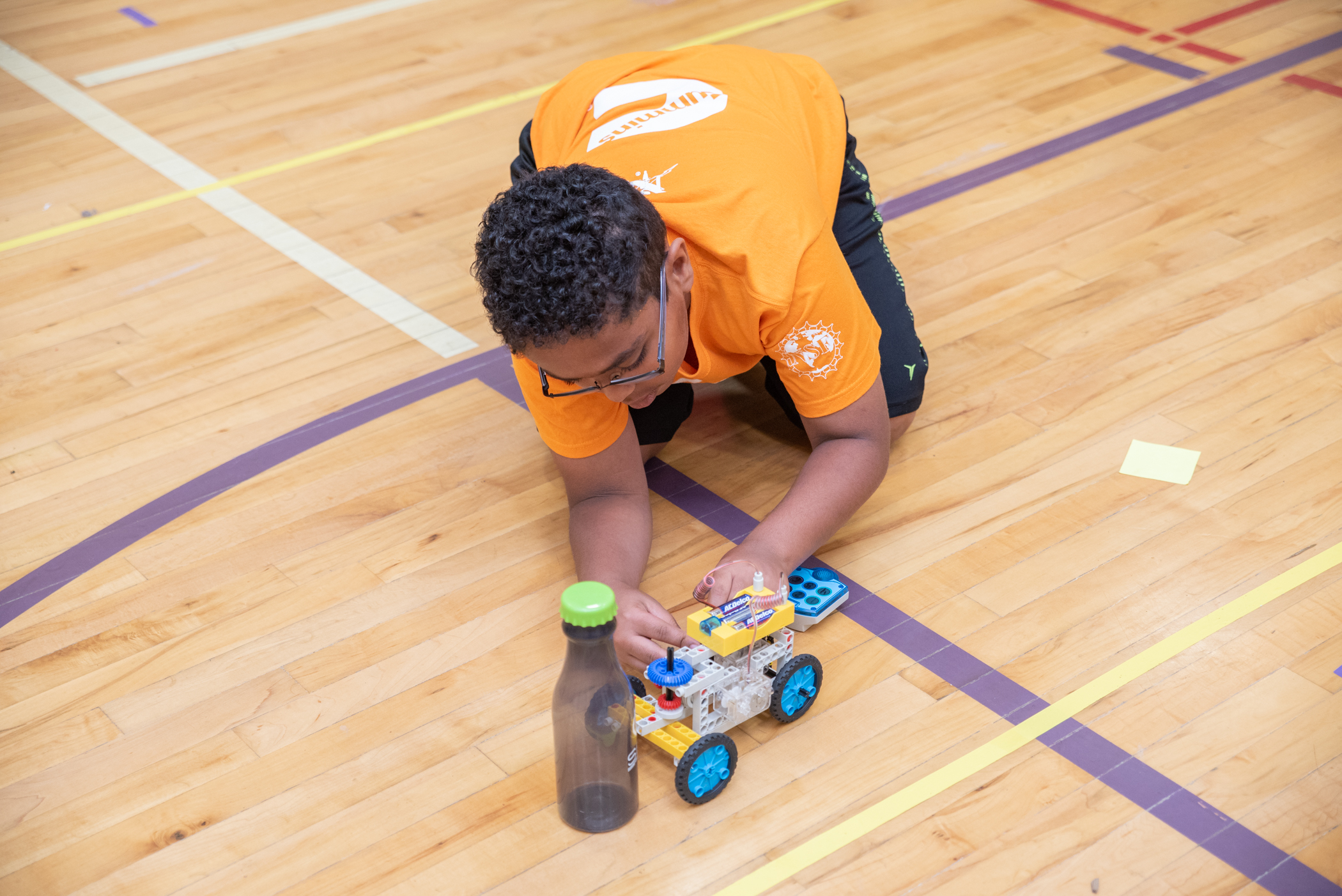 Fourth grade future engineer makes some last minute adjustments to his team’s robot.