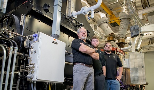 Seymour Engine Plant employees stand in front of one of the plant's regen dynos.