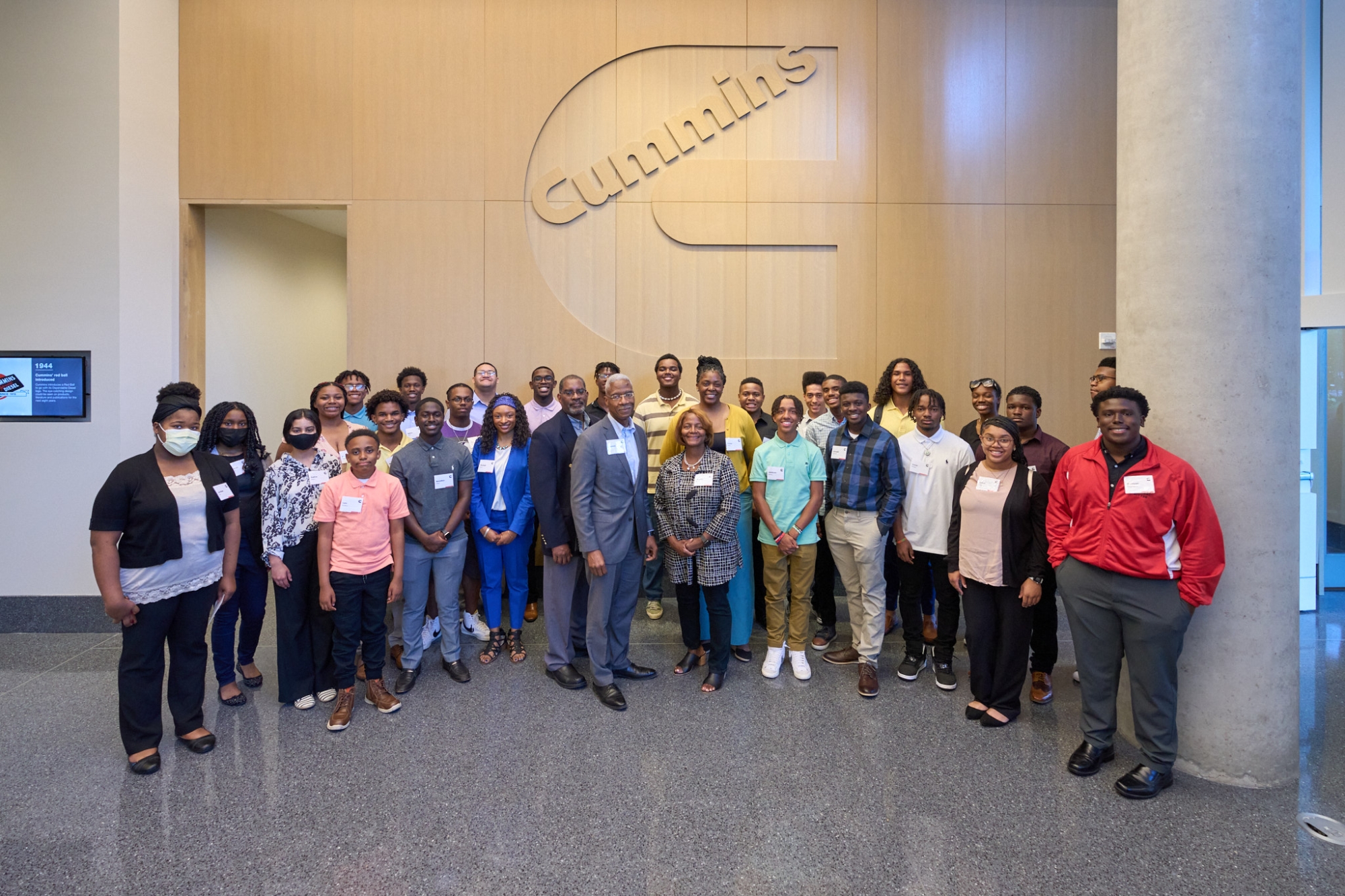 employees standing in front of company logo