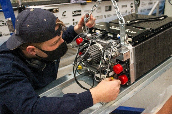 A TU Delft Solar Team member working to  install the Cummins HyPM-HD30 fuel cell