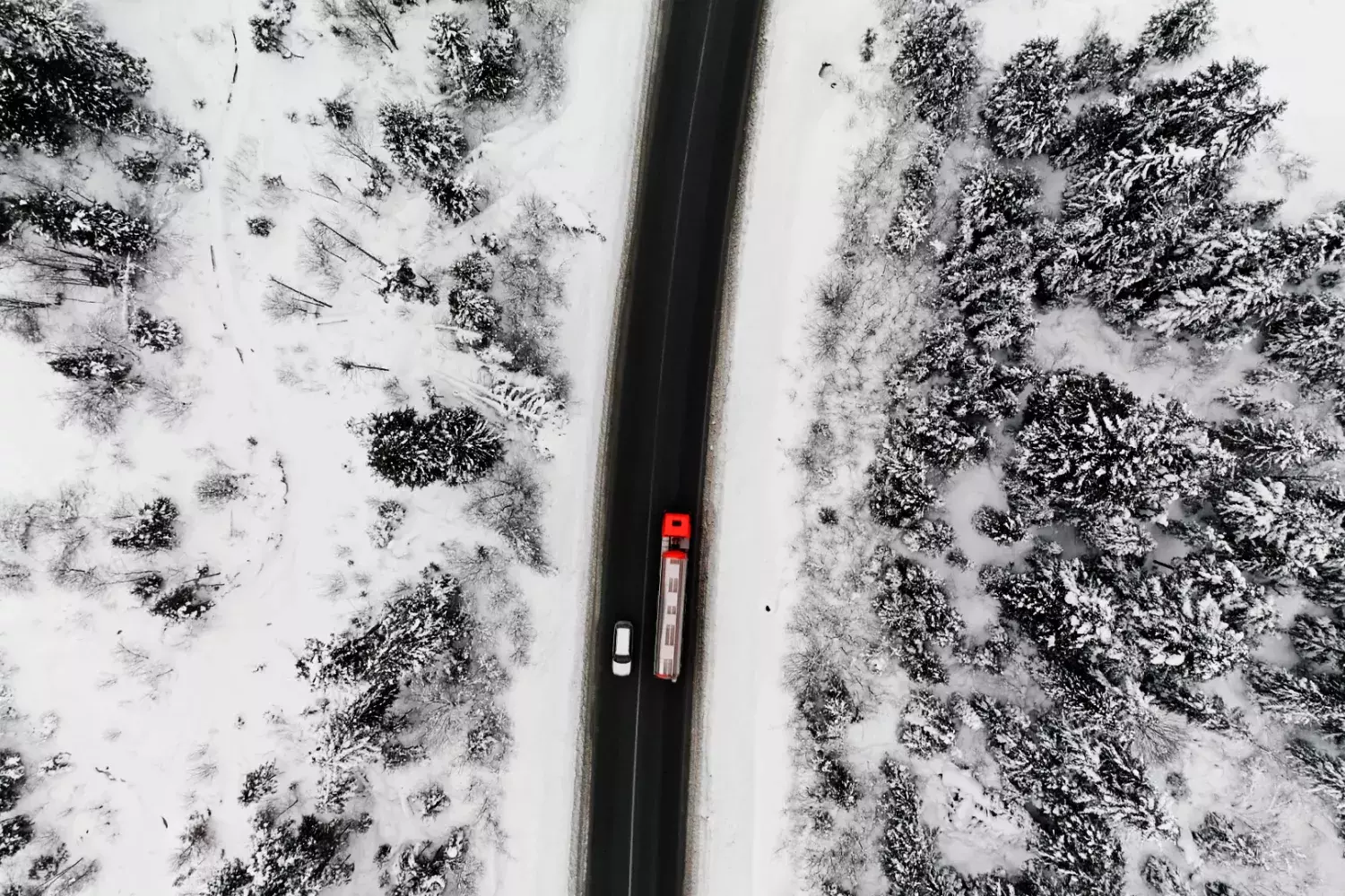 overhead of semi-truck driving on snowy road