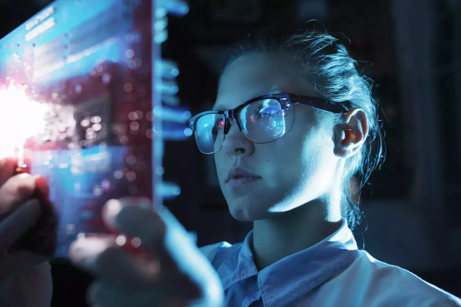 woman wearing safety glasses views a tablet with data