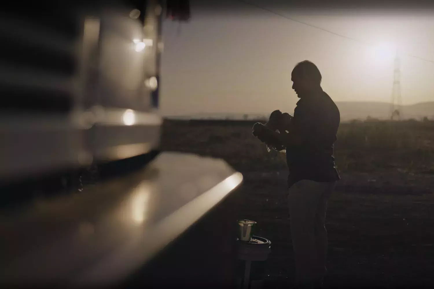 truck driver in india washes his face with a desert in the background