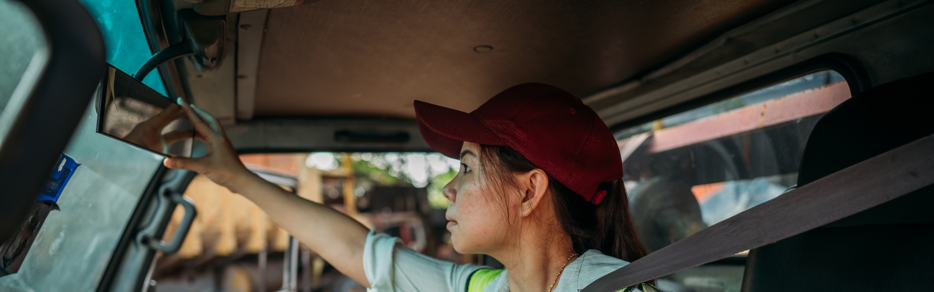 Truck driver adjusting rear-view mirror