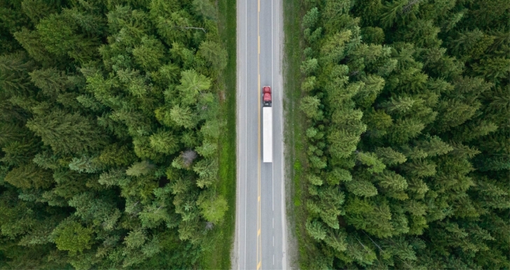 semi truck driving through forest
