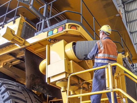 Worker changing filter on a large dump truck