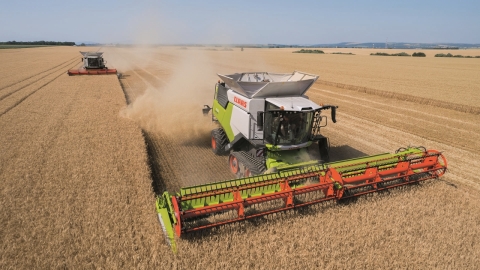 two combines in a field harvesting crops