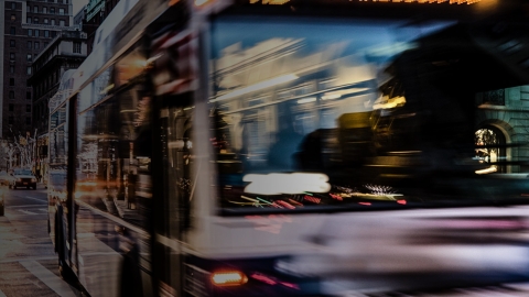 blurry shot of a bus in action driving through a busy city street