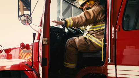 Firefighter closing door of fire engine.