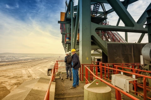 two construction employees on a site overlooking a desert landscape