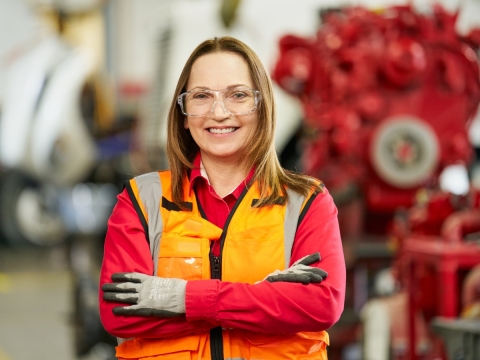 female service tech with engine in the background