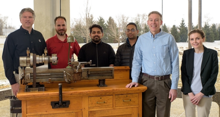  Michael Blanz (second from right) and his team gather around the lathe Clessie Cummins used to invent the Jake brake.