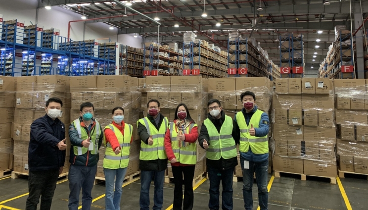 Cummins employees in Shanghai stand in front of one of the shipments of masks.