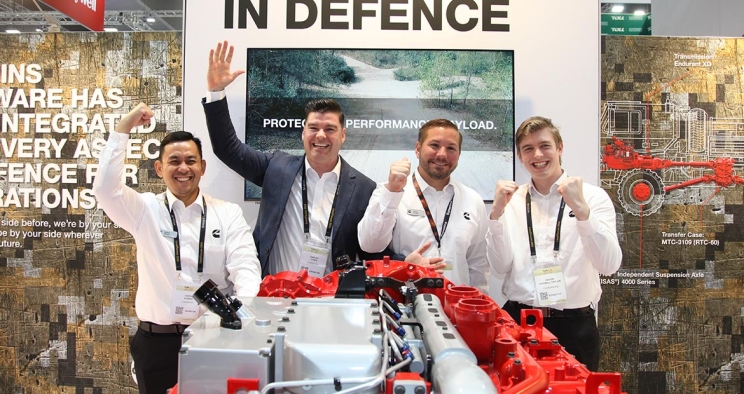 Employees next to engine at trade show