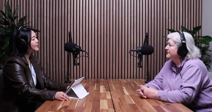 Podcast host and guest talking into microphones