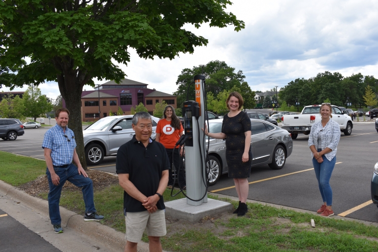 Team members gather around the new electric vehicle charging station developed in the city of Shoreview, Minnesota. Cummins employees contributed to the effort and are now working to create a charging station in the city of White Bear Lake (photo courtesy of the Great Plains Institute).