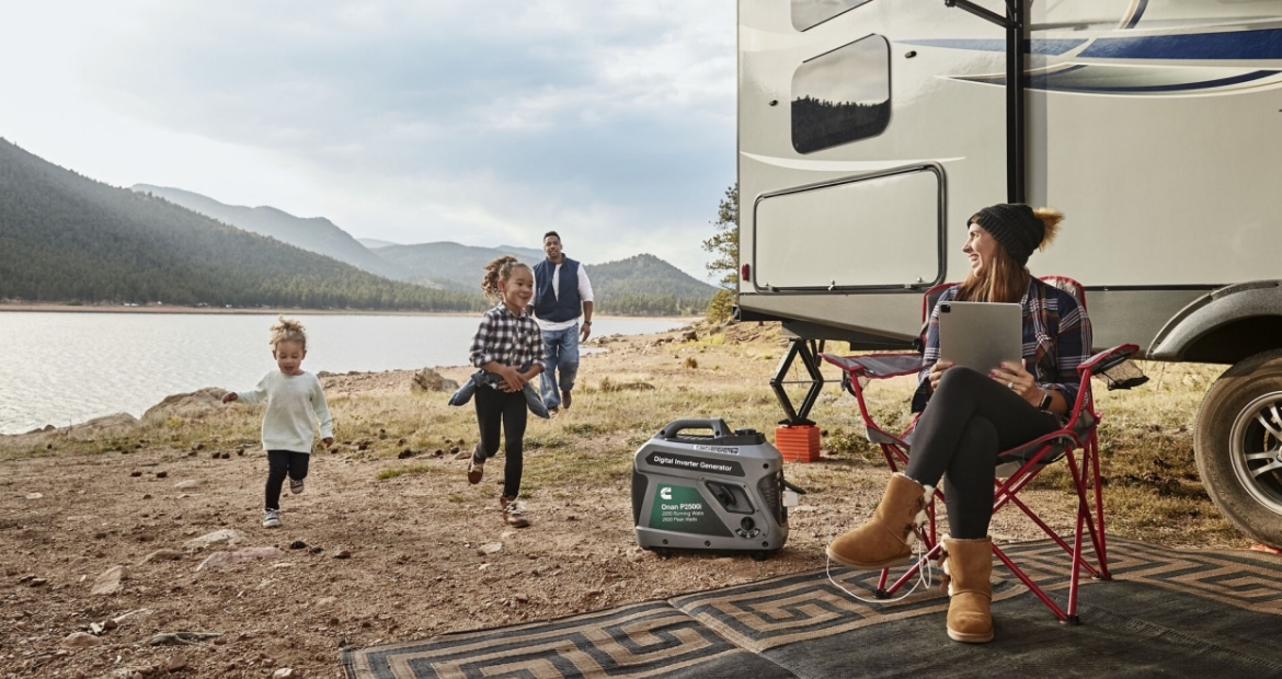 family enjoying rv camping near water and mountains with a cummins portable generator