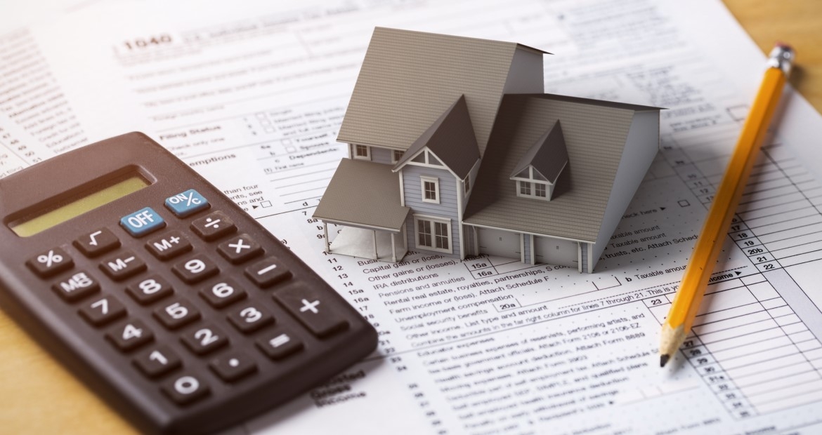 Calculator with small house on a table