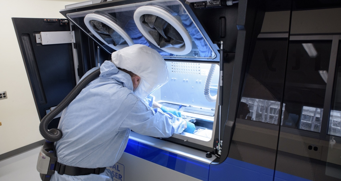 Cummins employee Devin Hunter cleans one of the company’s 3D printers at the Cummins Technical Center in Columbus, Indiana, before another round of printing. Metal 3D printers could revolutionize manufacturing.