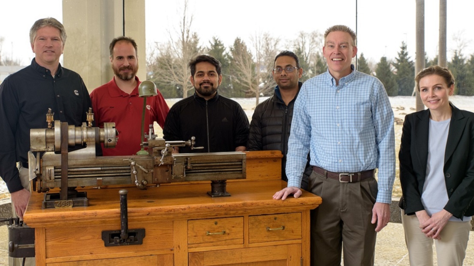 Michael Blanz (second from right) and his team gather around the lathe Clessie Cummins used to invent the Jake brake.