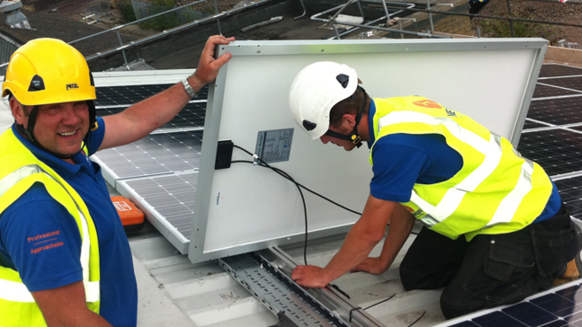 workers wearing safety equipment install solar panels