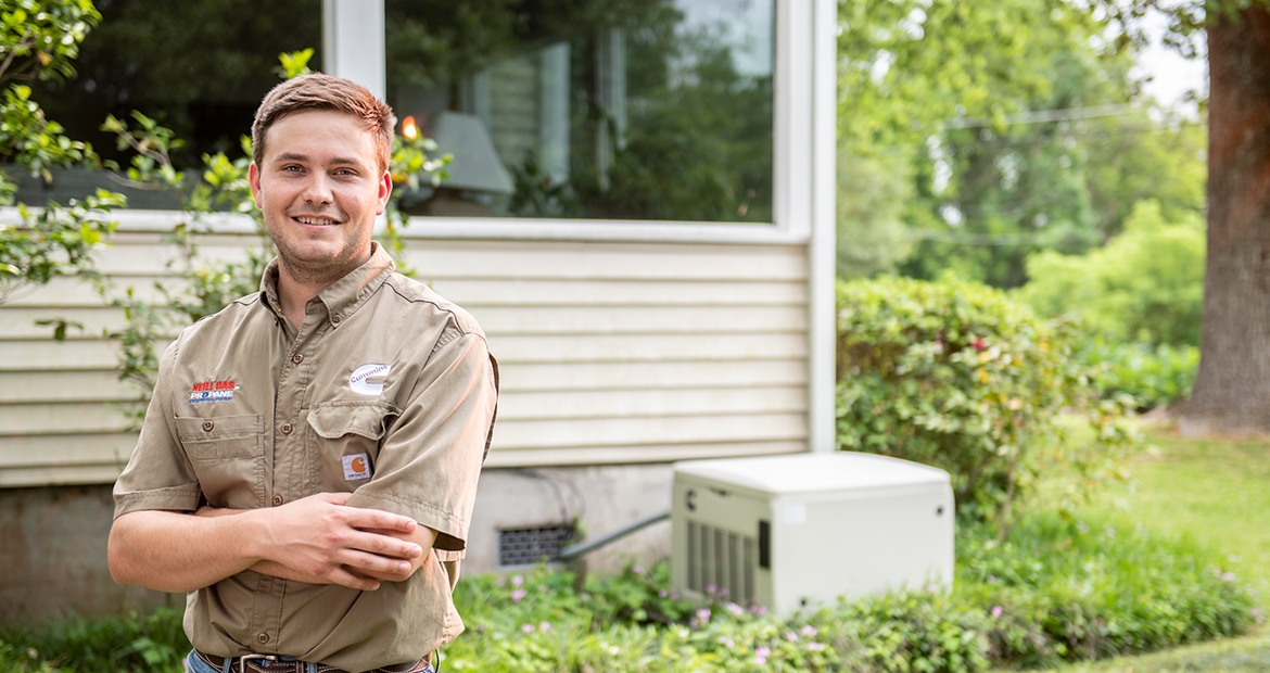 Cummins dealer smiling next to home generator