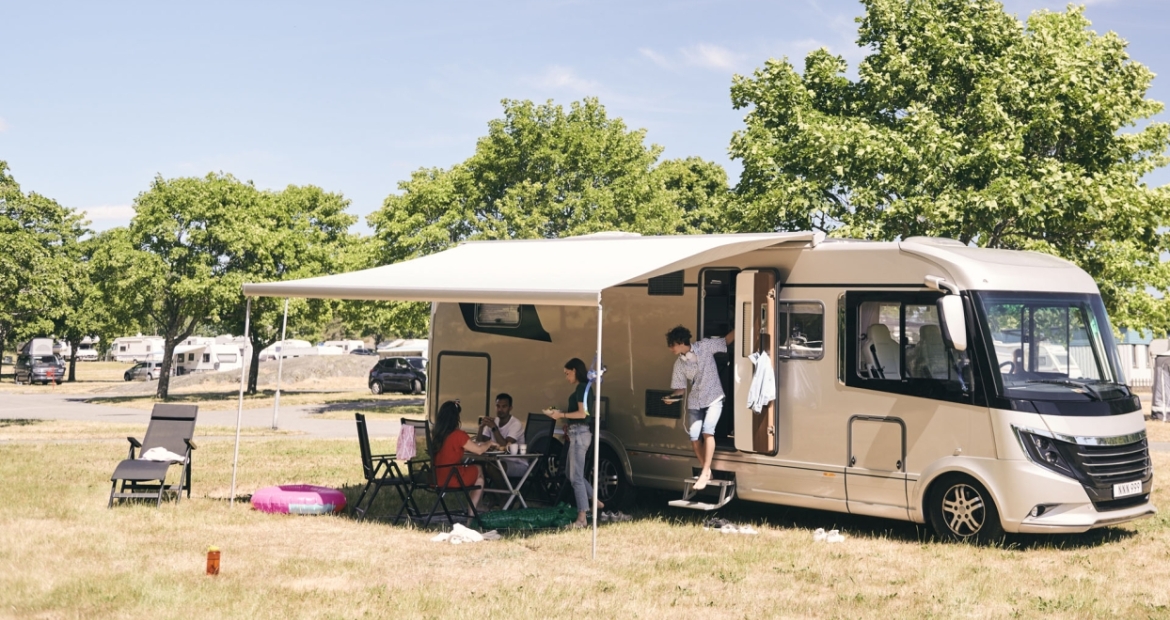 a family gathers for a meal under their rv canopy