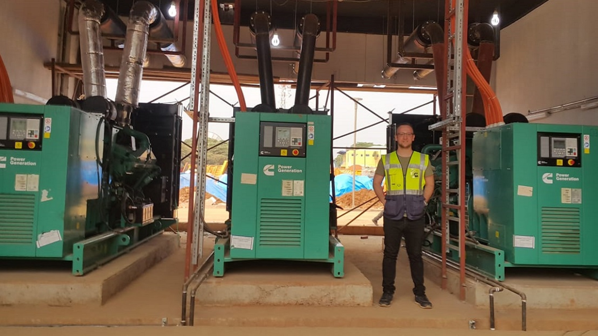 Adem Ersoy, Project Engineer at Cummins Turkey's authorized distributor Mepa Energy, stands next to the standby power system at Kigali Arena. Adem Ersoy, Project Engineer at Cummins Turkey's authorized distributor Mepa Energy, stands next to the standby power system at Kigali Arena.