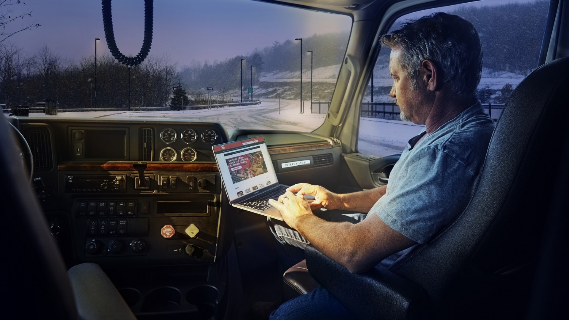 A truck passenger uses shop.cummins.com on a laptop inside the cab.