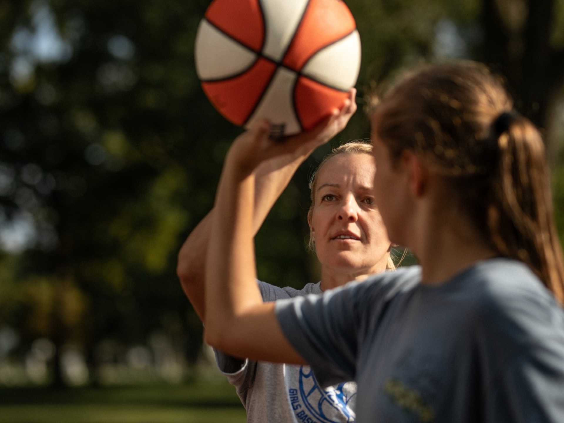 woman coaching youth player shooting form