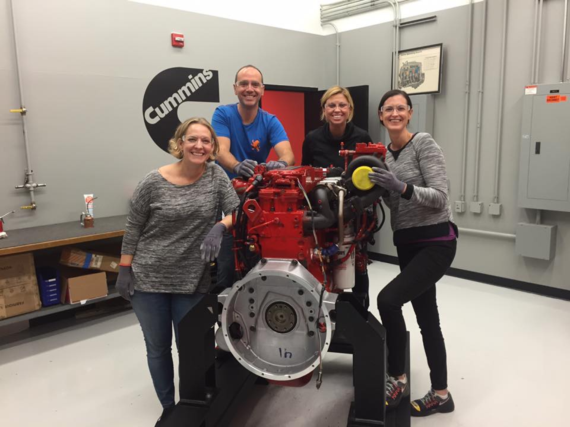 People surrounding around a Cummins engine