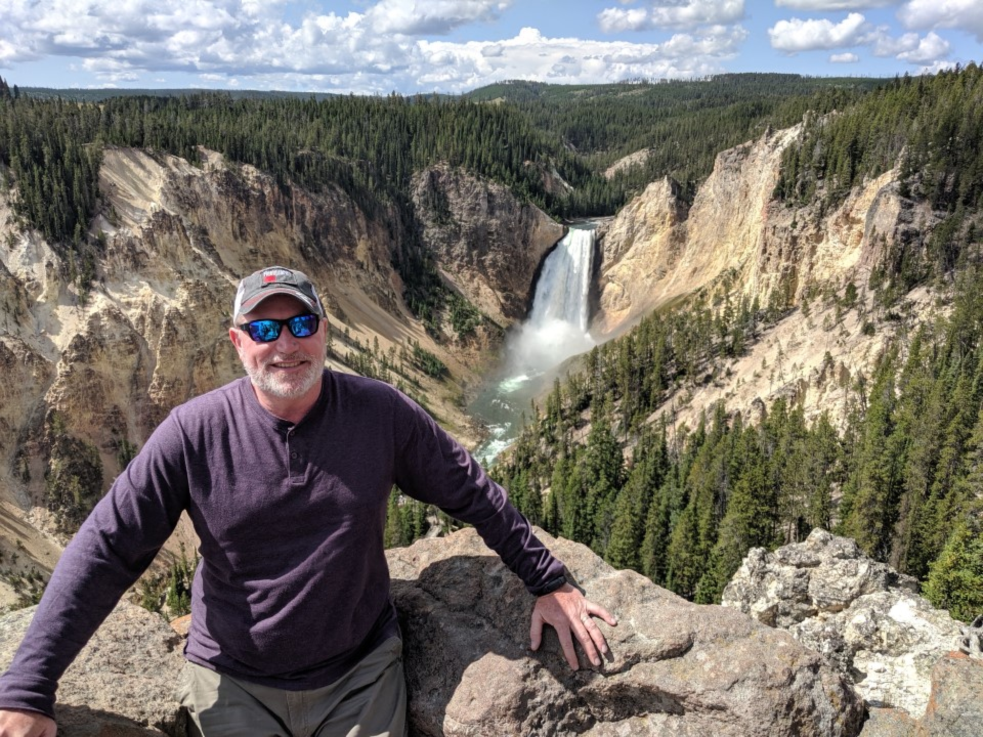 David posing in front of a waterfall