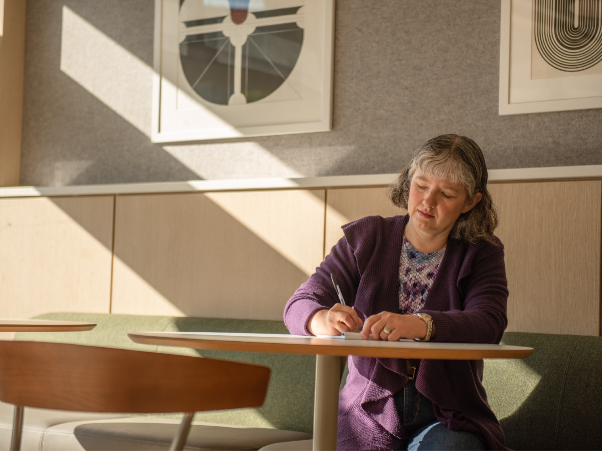 Jennifer, a Cummins engineer, writes in her notebook in a modern office