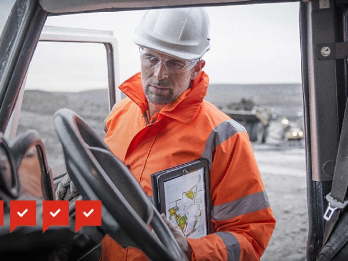 miner inspecting tablet in truck