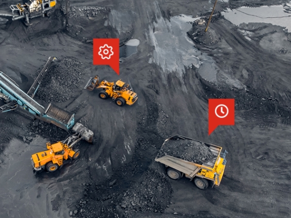 overhead view of large mining vehicles in action with red gear and clock icons