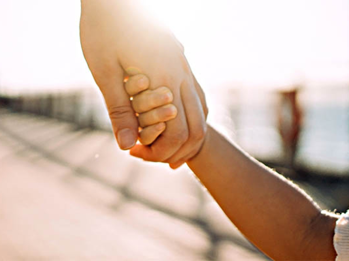 child holding hand of parent