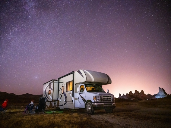 Rv in field with night sky in background