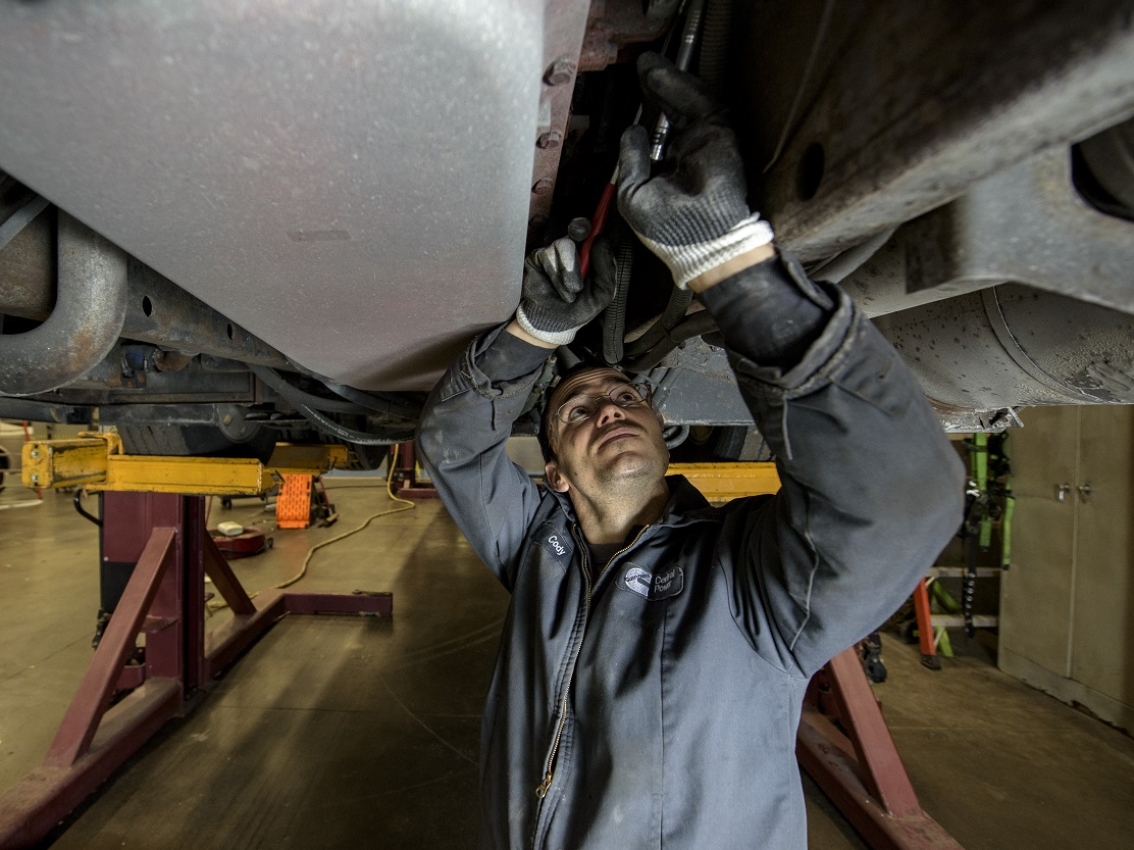 Mechanic making repairs under a vehicle