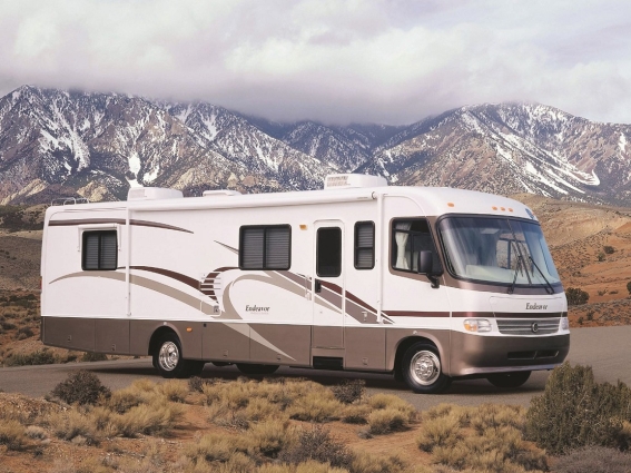 RV parked in the desert with mountains in the background