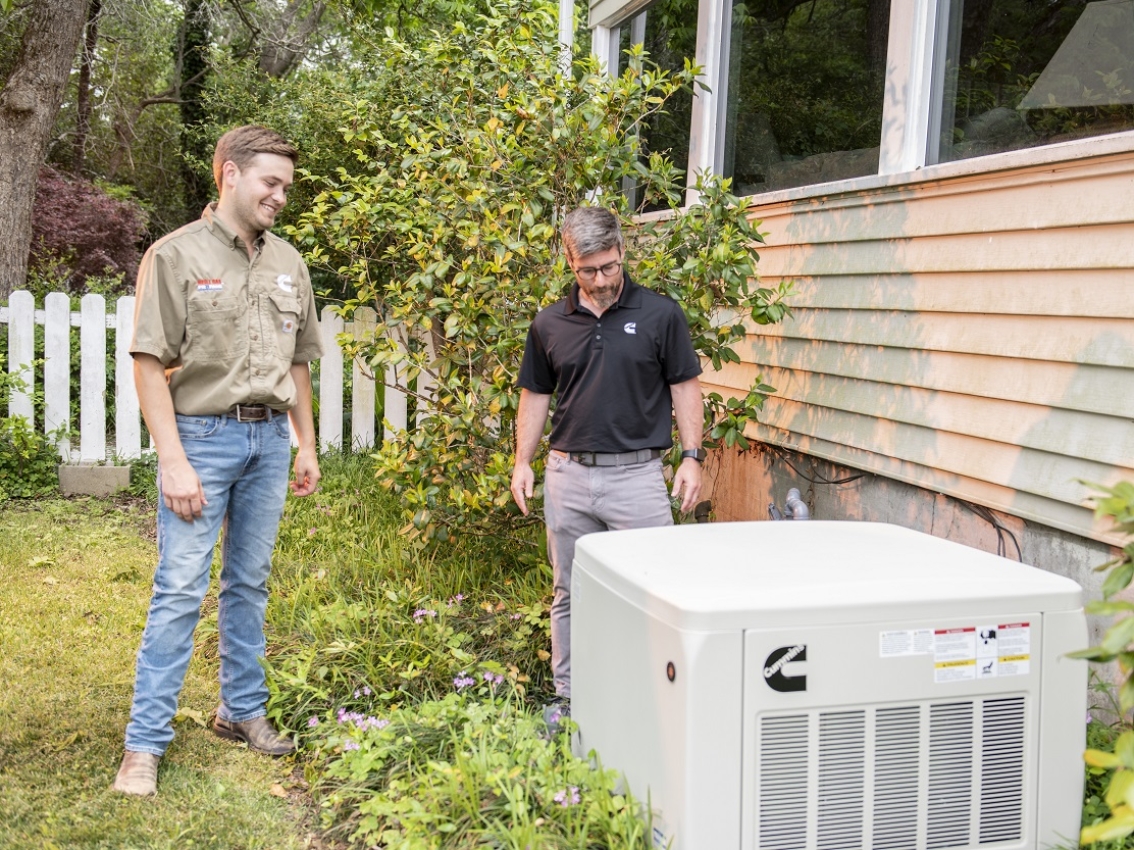 Cummins workers with home generator outside