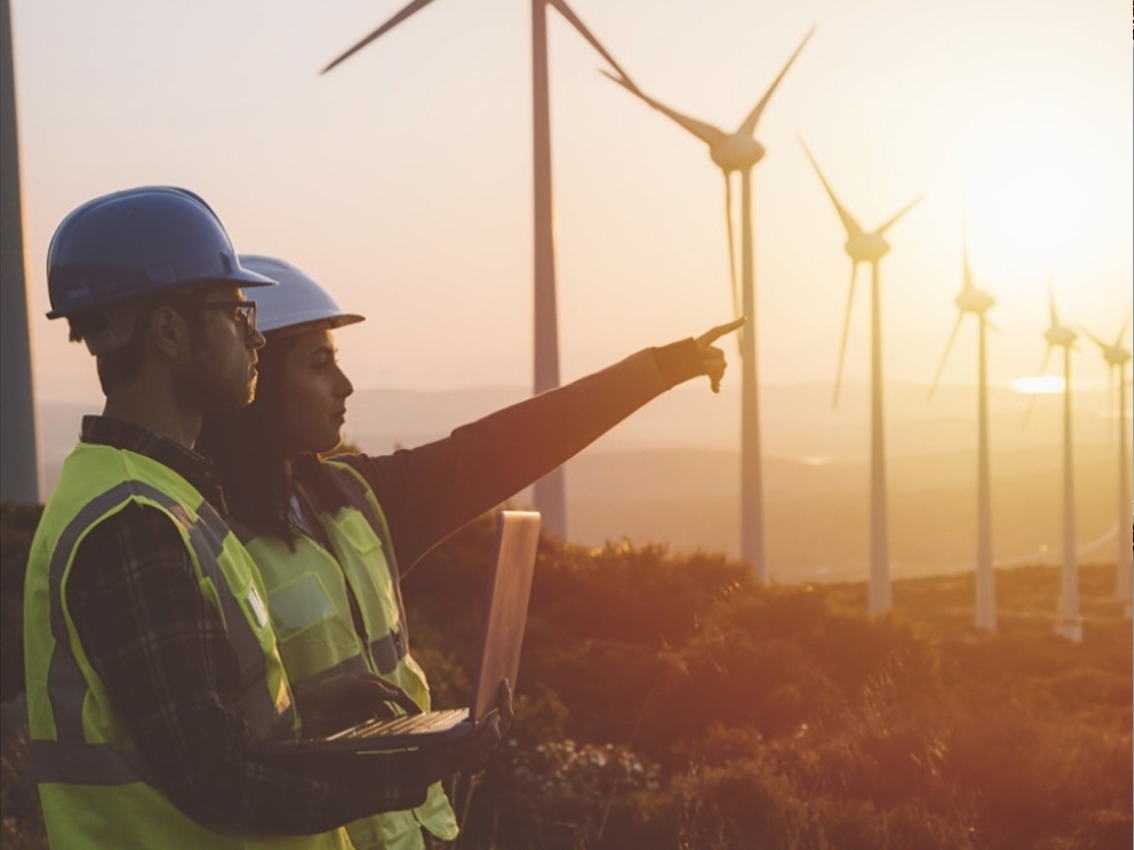 Workers with windmills behind them